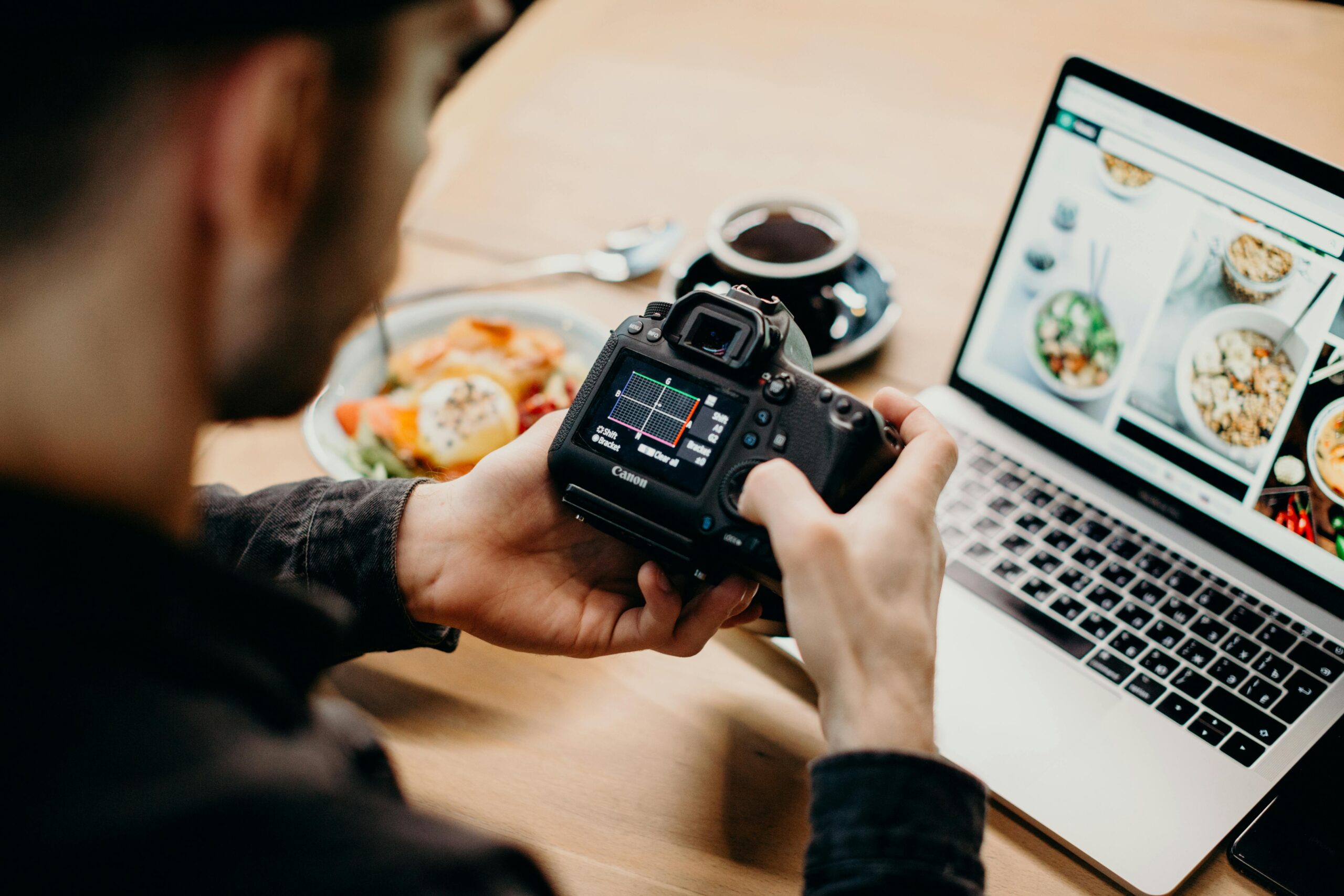 A photographer checking his camera and his website is opened on the screen. 